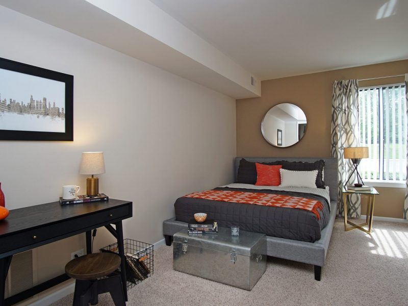 This image shows the spacious bedroom area showcasing the light tone color wall, elegant bedding, and minimal wall decor.