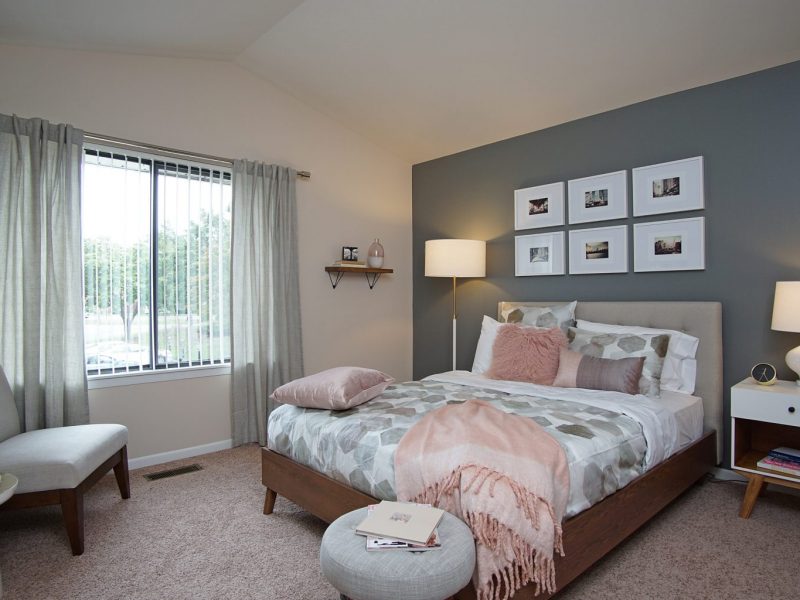 This image exhibits the bedroom area showcasing the radiant tone wall and elegant bedding.