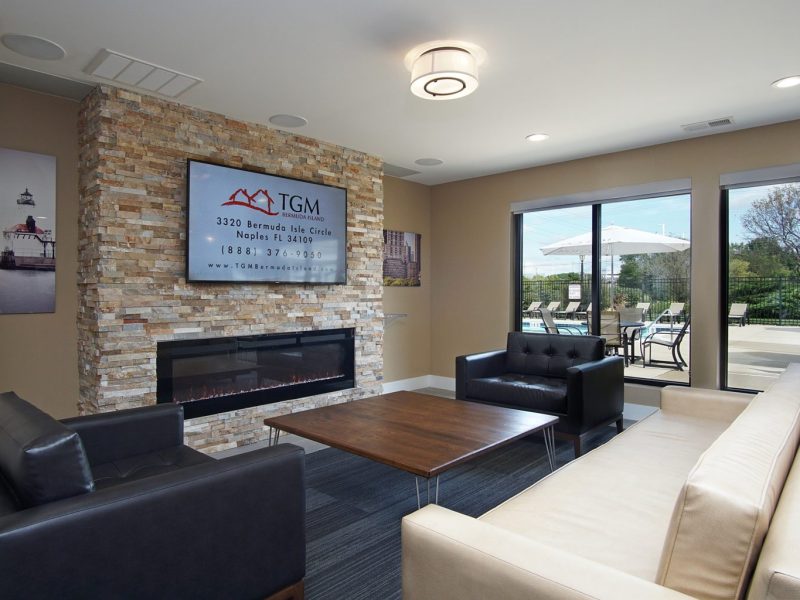 This image shows the newly renovated clubhouse featuring a café Lounge with fresh coffee and wi-fi. It features a fireplace and flat-screen TV while overlooking the outdoor kitchen.