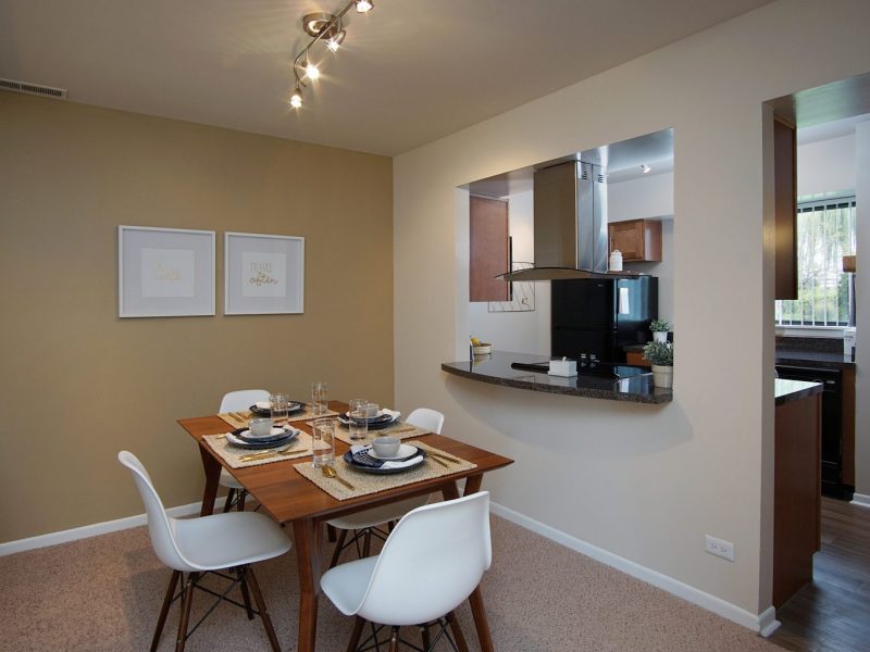 This image shows the Premium Apartment Feature, particularly the dining room area featuring minimalist decor, elegant furniture, and a wooden dining table that was suitable for a spacious area.