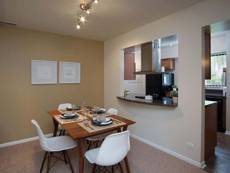 This image shows the Premium Apartment Feature, particularly the dining room area featuring minimalist decor, elegant furniture, and a wooden dining table that was suitable for a spacious area.
