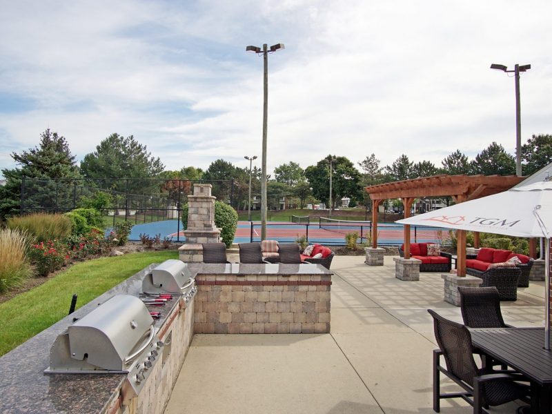 This image shows the outdoor kitchen, featuring the grilling area and lounge with a fireplace.