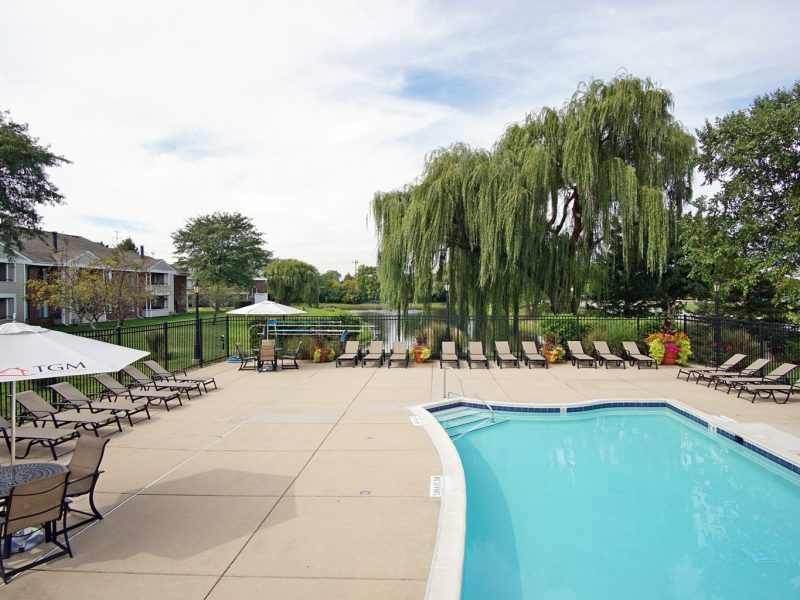 This image shows the resort-style swimming pool in TGM McDowell Place featuring the spacious area, relaxing pool beds, and a scenic view beside the lake.