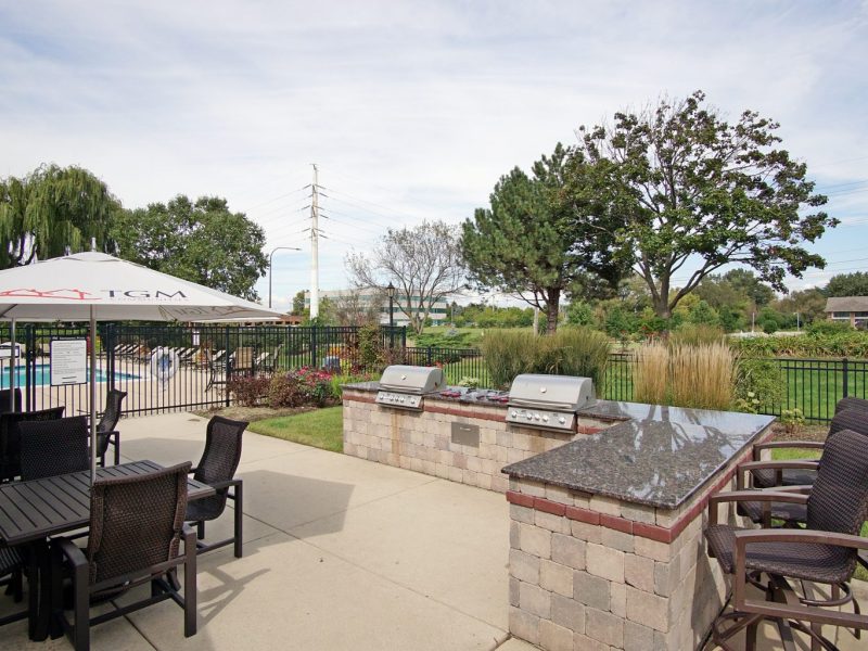 This image shows a gourmet-inspired outdoor kitchen with high-end details and a breakfast bar.